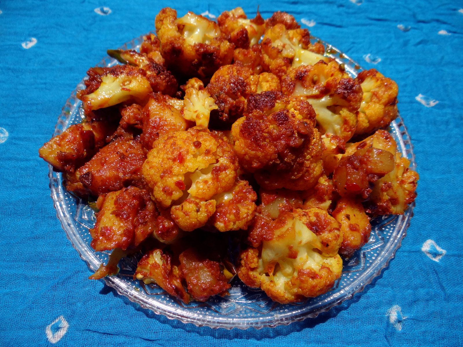Gobi masala, spiced cauliflower, in a steel bowl on a dark backdrop