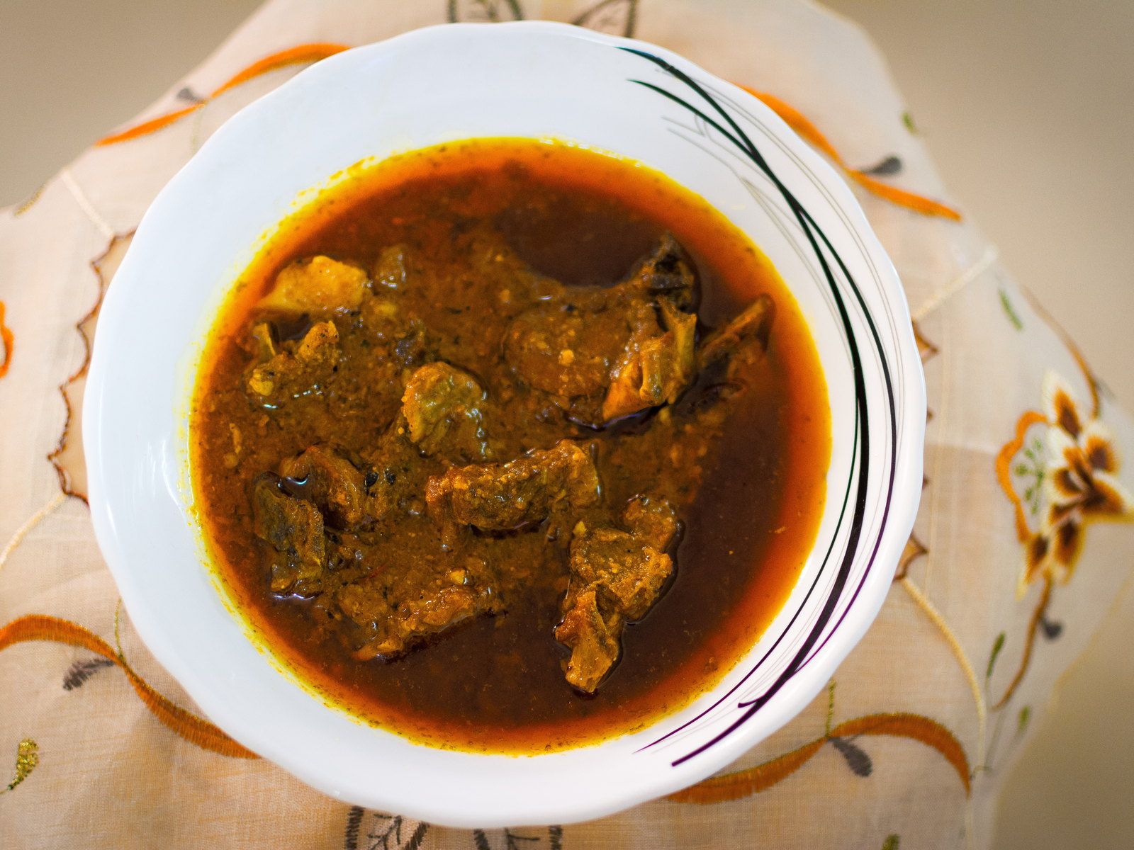 Lamb korma in a scalloped porcelain bowl with a golden cashew gravy
