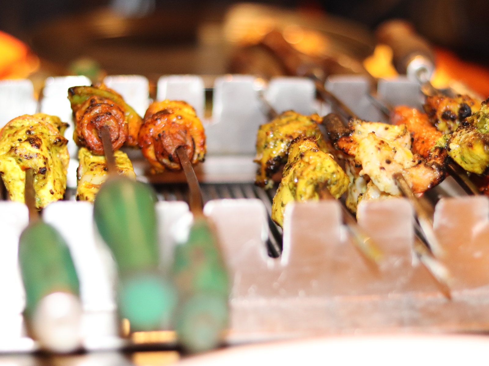 Grilled paneer tikka skewers with capsicum and onion on a white tray