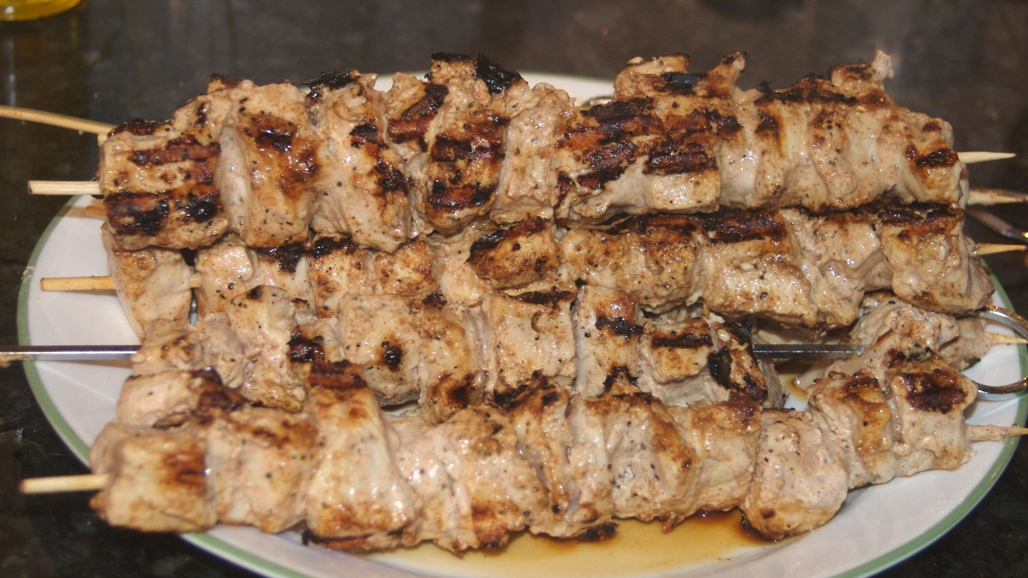 Marinated chicken skewers grilled over an open flame